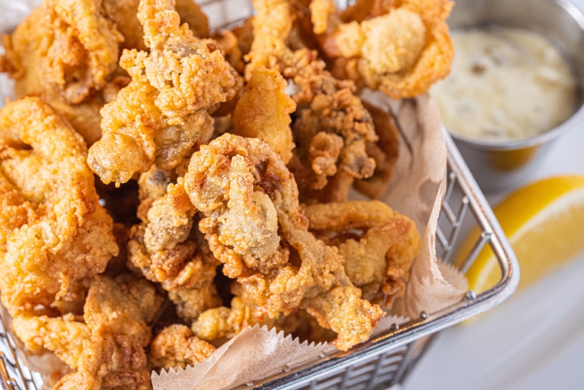 Crispy calamari starter in metal basket.